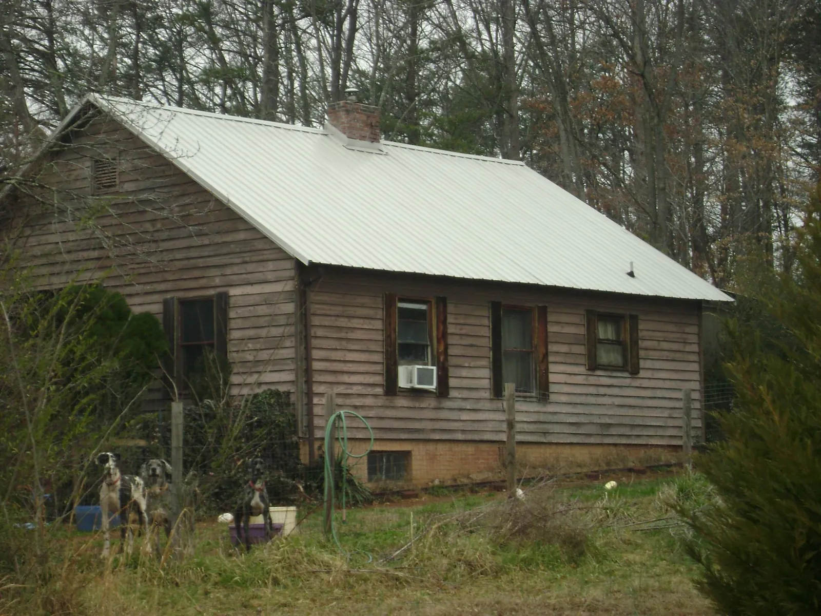 White metal roof on an old wood sided farmhouse, from a Metal Roof Installation job in Metamora